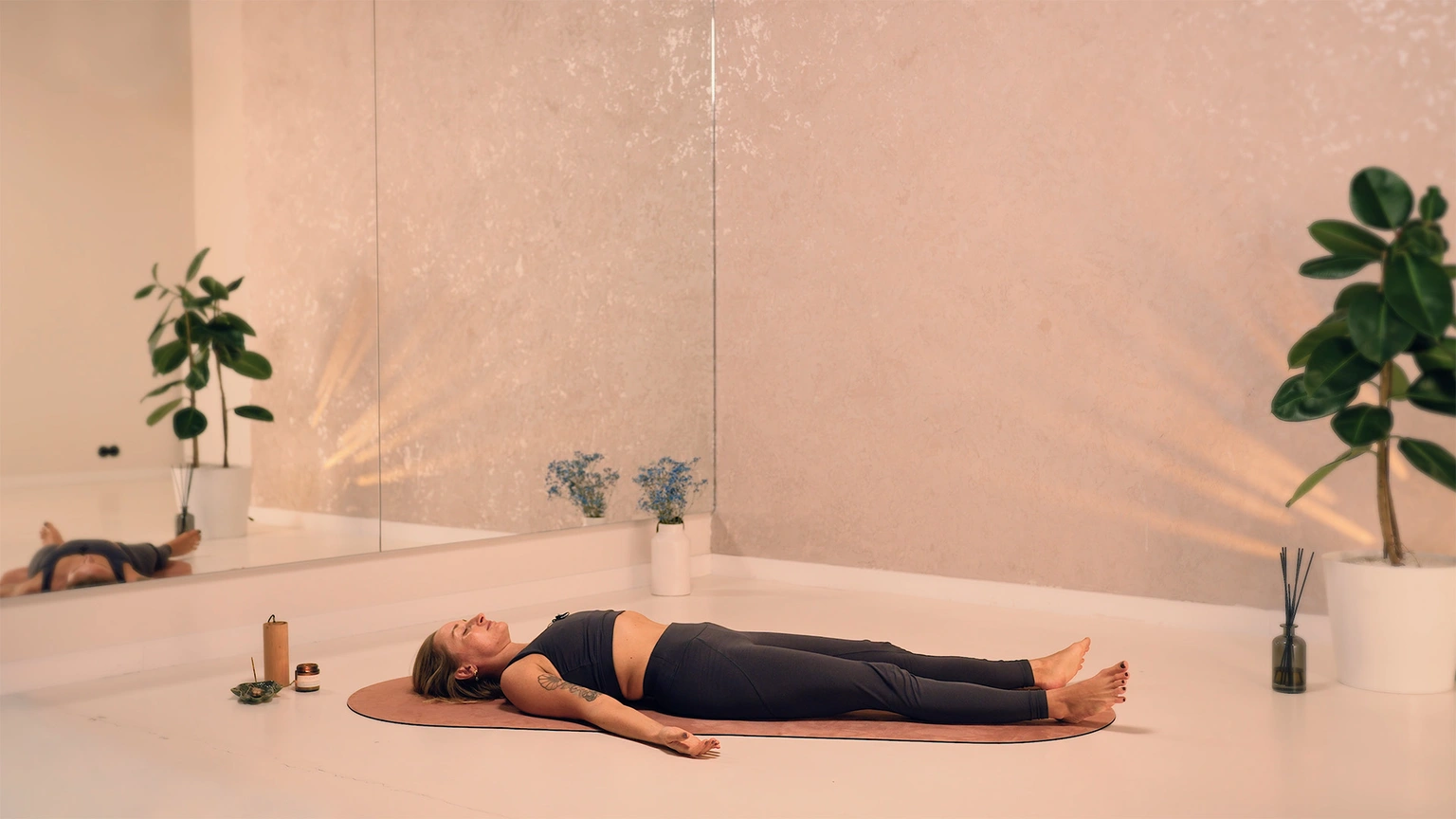 kobieta leży w pozycji relaksacyjnej podczas spokojnej praktyki jogi